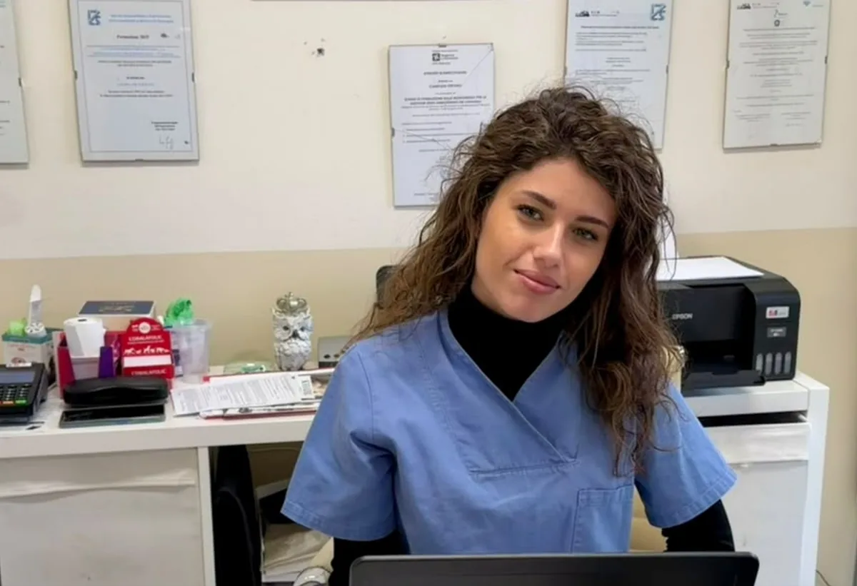Fabiana Vignoni con il camice blu, seduta alla scrivania